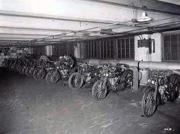 Black and white image of motorcycles in a garage