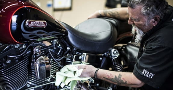 Guy cleaning a Harley Davidson motorcycle