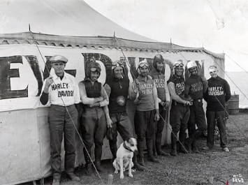 Black and white image of Harley Davidson riders and their dog