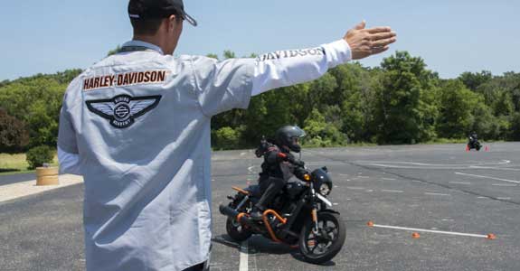 A man diving instructions to someone riding a motorcycle