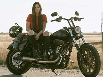 Woman sitting on a Harley Davidson motorcycle