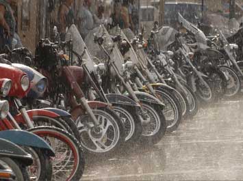 A row of motorcycles in the rain