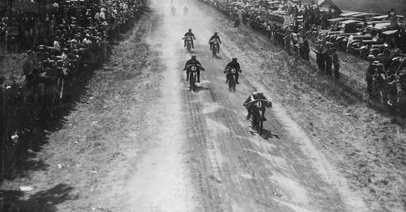 Old black and white image of motorcycles racing