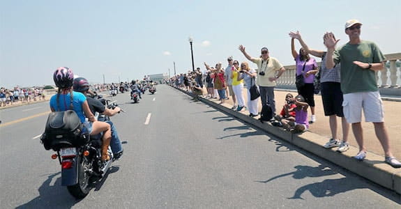 Two people riding a motorcycle in a parade