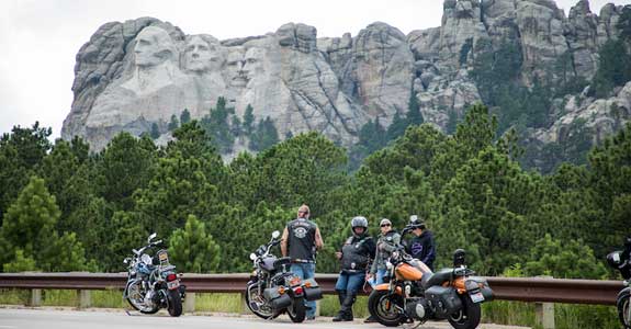 Motorcycles parked on a road in front of Mount Rushmore